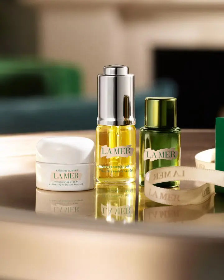 La Mer skincare products arranged on a pale surface